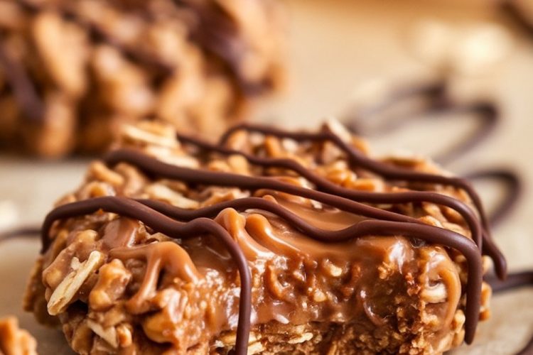 A single image showing a peanut butter chocolate caramel cookie with a bite taken, revealing a gooey caramel center, topped with chocolate drizzle, and scattered oats on parchment paper.