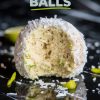 A close-up of a single coconut lime ball with a bite missing. The ball is coated in shredded coconut and lime zest, resting on a glossy black surface. The text overlay reads "Zesty Coconut Lime Balls" in bold green and white font.