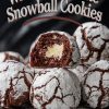 Close-up of white chocolate snowball cookies with powdered sugar coating and rich chocolate crinkle texture. One cookie is split open, revealing a creamy white chocolate center. The cookies are arranged on a black marble serving plate. Overlay text reads: “White Chocolate Snowball Cookies.”