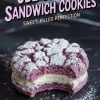 Close-up of an ube crinkle sandwich cookie with a bite taken out, showing the fluffy purple cookie layers and smooth white cream filling. The cookie is dusted with powdered sugar, and text overlay reads “Ube Crinkle Sandwich Cookies - Sweet, Filled Perfection.”