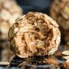 Detailed shot of a peanut butter-filled oatmeal energy ball with a bite taken out, revealing a creamy, rich peanut butter center surrounded by oats and cinnamon.