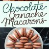 A styled composition of chocolate ganache macarons stacked in a tower and arranged in a circle, emphasizing their smooth shells and creamy chocolate filling, accompanied by text reading “Chocolate Ganache Macarons.”