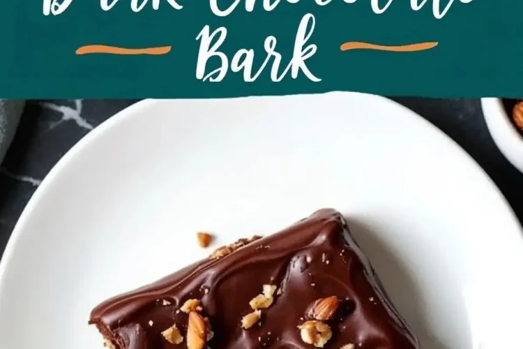 A close-up of dark chocolate bark topped with chopped nuts, placed on a white plate. The glossy chocolate surface contrasts with the crunchy nut topping. A text overlay reads “Dark Chocolate Bark.”