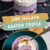 Glass cups filled with layers of ube halaya trifle, featuring vibrant purple ube mousse, white whipped cream, and a crunchy golden topping. The dessert is presented on a dark marble surface, with a spoonful lifted to showcase its creamy texture and rich layers. The text overlay reads “UBE HALAYA EASTER TRIFLE.”