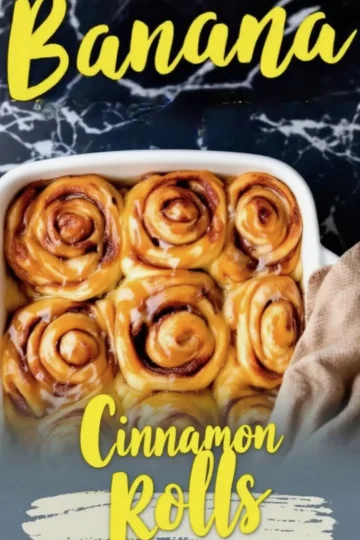 Banana cinnamon rolls baked in a white dish, swirled and golden with glossy caramelized banana glaze, set against a black marble backdrop with yellow text overlay.