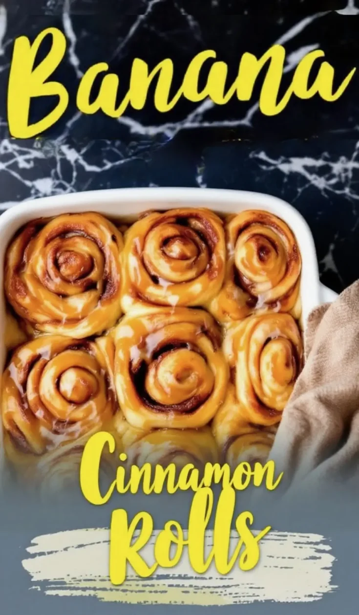 Banana cinnamon rolls baked in a white dish, swirled and golden with glossy caramelized banana glaze, set against a black marble backdrop with yellow text overlay.