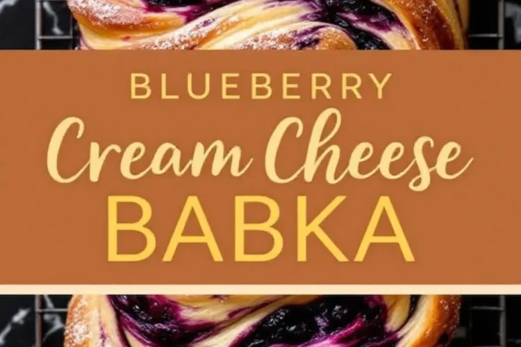 Blueberry cream cheese babka with a golden brown crust, swirls of blueberry filling, and a dusting of powdered sugar. The twisted dough design reveals layers of soft bread and rich filling. The babka sits on a cooling rack over a black marble surface, with a brown text overlay that reads “Blueberry Cream Cheese Babka.”