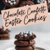 A close-up of chocolate confetti cookies with pastel pink and blue candy pieces on a dark marble background. The text overlay reads “Chocolate Confetti Easter Cookies.” Below, a stack of thick cookies is topped with a bitten cookie, revealing a soft and fudgy inside.