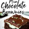 A slice of mint chocolate brownie on a white plate, featuring a fudgy brownie base, a thick layer of mint frosting, and a glossy chocolate ganache topping, garnished with fresh mint leaves. The image includes bold text reading “Mint Chocolate Brownies.”