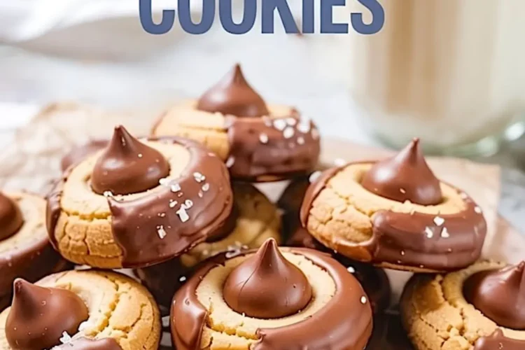Chocolate-dipped peanut butter blossom cookies with Hershey’s kisses and sea salt served with a glass of milk, styled for a cozy dessert moment.