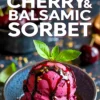 A close-up of two scoops of black cherry balsamic sorbet in a dark ceramic bowl, drizzled with thick balsamic reduction and garnished with a sprig of fresh basil, with text overlay promoting the sorbet.