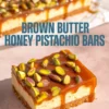 Close-up of brown butter honey pistachio bars with a golden caramel glaze and whole pistachios on top, showcasing the creamy layered filling and crunchy crust.