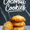 Stack of golden brown coconut cookies topped with toasted shredded coconut on a round plate, set against a dark marbled background with bold “Coconut Cookies” text above.