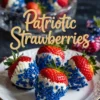 Patriotic-themed strawberries dipped in white chocolate and blue sprinkles, served on a white plate with a glass bowl of more decorated strawberries in the background, with “Patriotic Strawberries” text overlay.