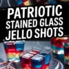 Patriotic stained glass jello shot in a clear glass served on a small plate, featuring colorful red, yellow, and blue gelatin cubes layered in a festive Fourth of July design.