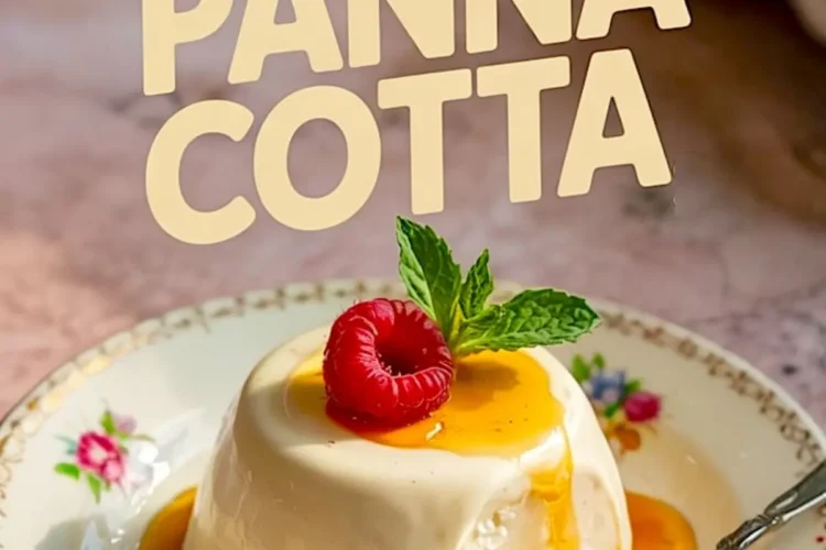 Silky vanilla panna cotta topped with a raspberry and mint, draped in caramel sauce, on a decorative porcelain plate with a spoonful taken out.