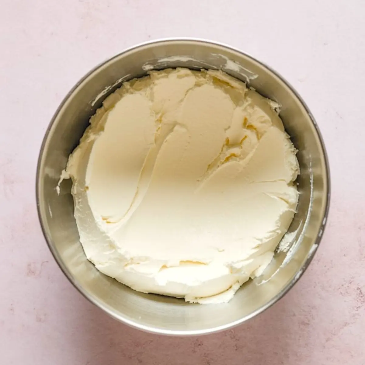 Large bowl filled with whipped cream cheese mixture, smooth and airy texture ideal for sweet dips or no-bake dessert recipes.