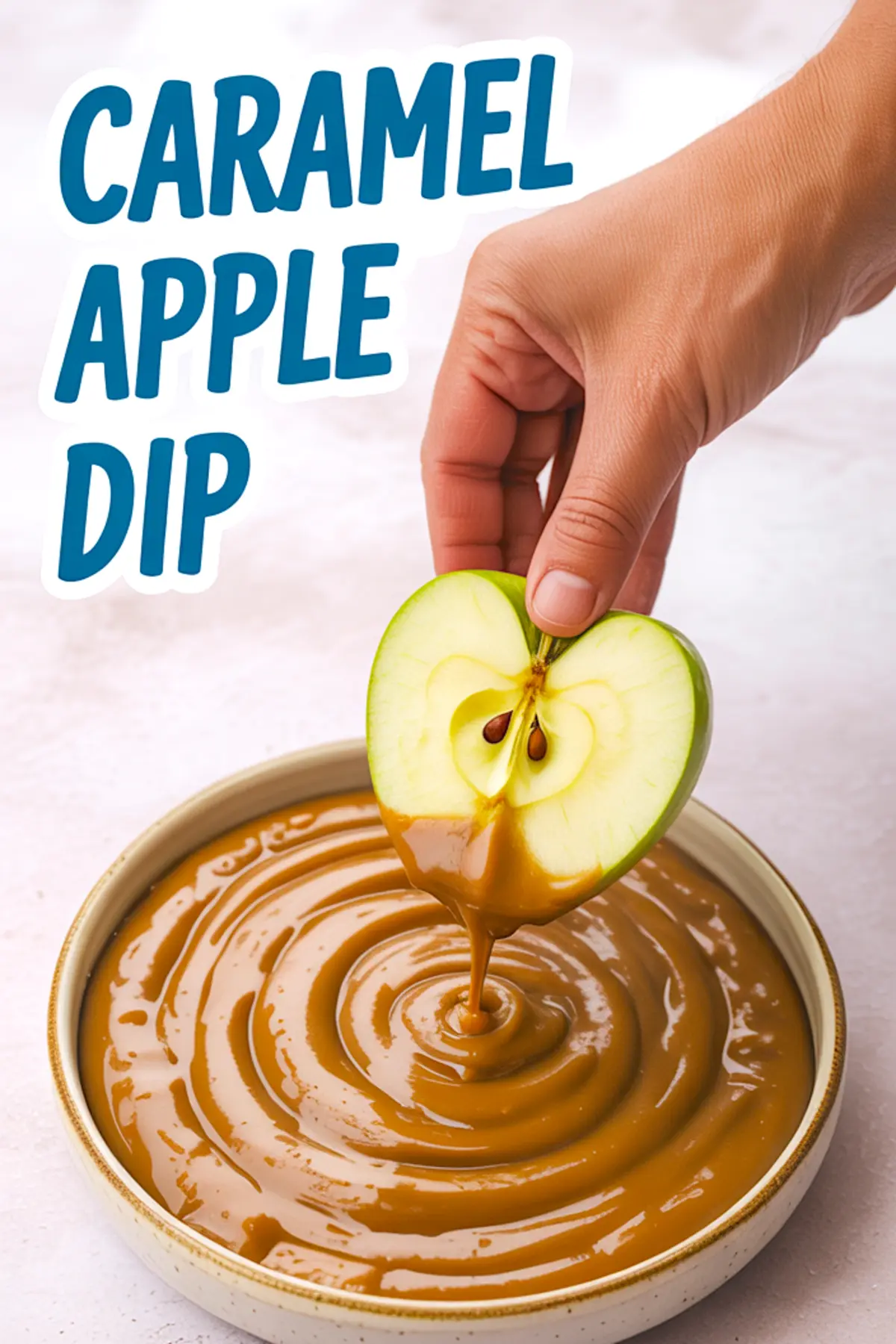 Hand dipping a halved green apple into a bowl of smooth caramel sauce, labeled “Caramel Apple Dip” in bold blue text.