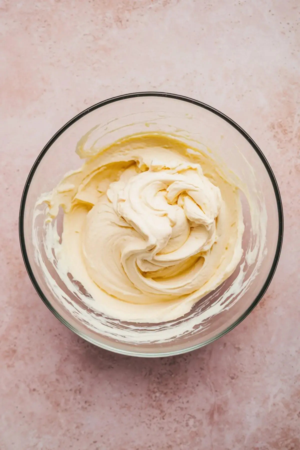 Fully blended cheesecake mixture in a clear bowl with a creamy, velvety texture, ready for serving or baking.