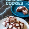 Plate of brownie crinkle cookies with powdered sugar coating and bold text “Brownie Crinkle Cookies,” with a blue plate in the background holding a broken cookie showcasing melted chocolate filling.