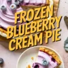 Overhead view of a sliced frozen blueberry cream pie with smooth purple filling, topped with whole blueberries, and one slice served on a white plate with crumbs scattered.