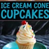 Decorated ice cream cone cupcake on a turquoise plate, topped with swirled frosting, rainbow sprinkles, and a maraschino cherry.