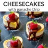Mini heart-shaped cheesecakes topped with rich chocolate ganache and fresh raspberries, arranged on a dark marbled surface with a glossy finish and a dusting of powdered sugar.