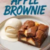 Apple brownie slice served on a white ceramic plate with a scoop of vanilla ice cream, melted slightly around the dessert.