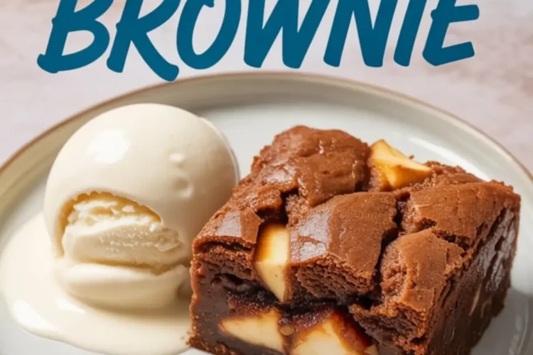 Apple brownie slice served on a white ceramic plate with a scoop of vanilla ice cream, melted slightly around the dessert.