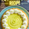 Overhead view of a decorated key lime pie with a swirled lime filling, whipped cream rosettes, and lime zest garnish, set on a teal plate with recipe text above.