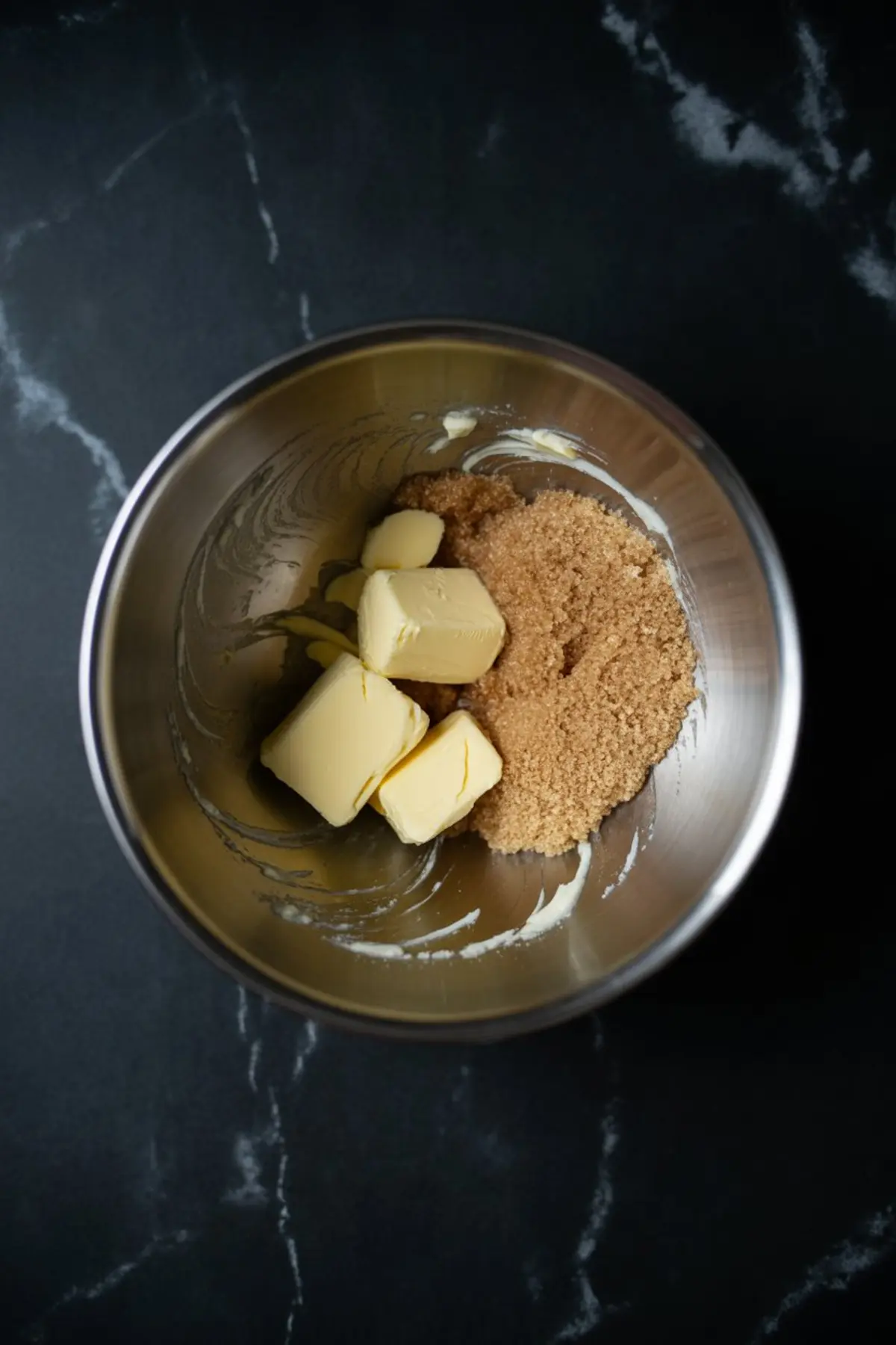 Mixing molasses cookie dough - butter and brown sugar creamed together in metal bowl, fall baking recipe process