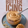 Collage showing a glass bowl of smooth peanut butter icing with a swirl tip in the center and a cupcake topped with matching frosting below, with text overlay “Peanut Butter Icing.”
