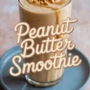 Tall glass of peanut butter smoothie topped with chopped peanuts and peanut butter drizzle, with bold text overlay reading “Peanut Butter Smoothie.”