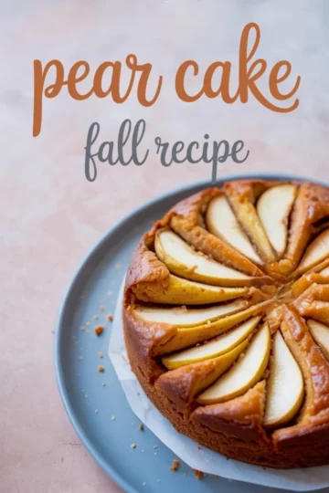 Round baked pear cake topped with sliced pears arranged in a circular pattern on a blue plate with text overlay reading “pear cake fall recipe.”