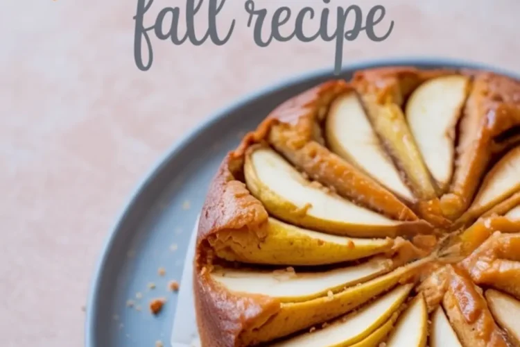 Round baked pear cake topped with sliced pears arranged in a circular pattern on a blue plate with text overlay reading “pear cake fall recipe.”