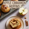 Freshly baked apple cinnamon muffins in a muffin tin, with one sliced muffin on a plate showing soft crumb and apple chunks, surrounded by apple slices and cinnamon sticks on a light surface.