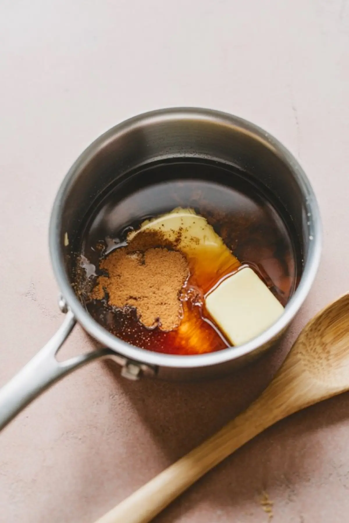 A saucepan filled with melted butter, brown sugar, and cinnamon, ready for making apple dumpling filling.