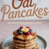 Stack of golden oat pancakes topped with fresh blueberries, raspberries, a square of butter, and a generous drizzle of maple syrup, with “Oat Pancakes - Simple healthy pancake recipe” in bold script above.