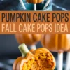 Pumpkin-shaped cake pops with an orange candy coating and green candy stems displayed in a teal cup, with one bitten open showing moist pumpkin cake inside.