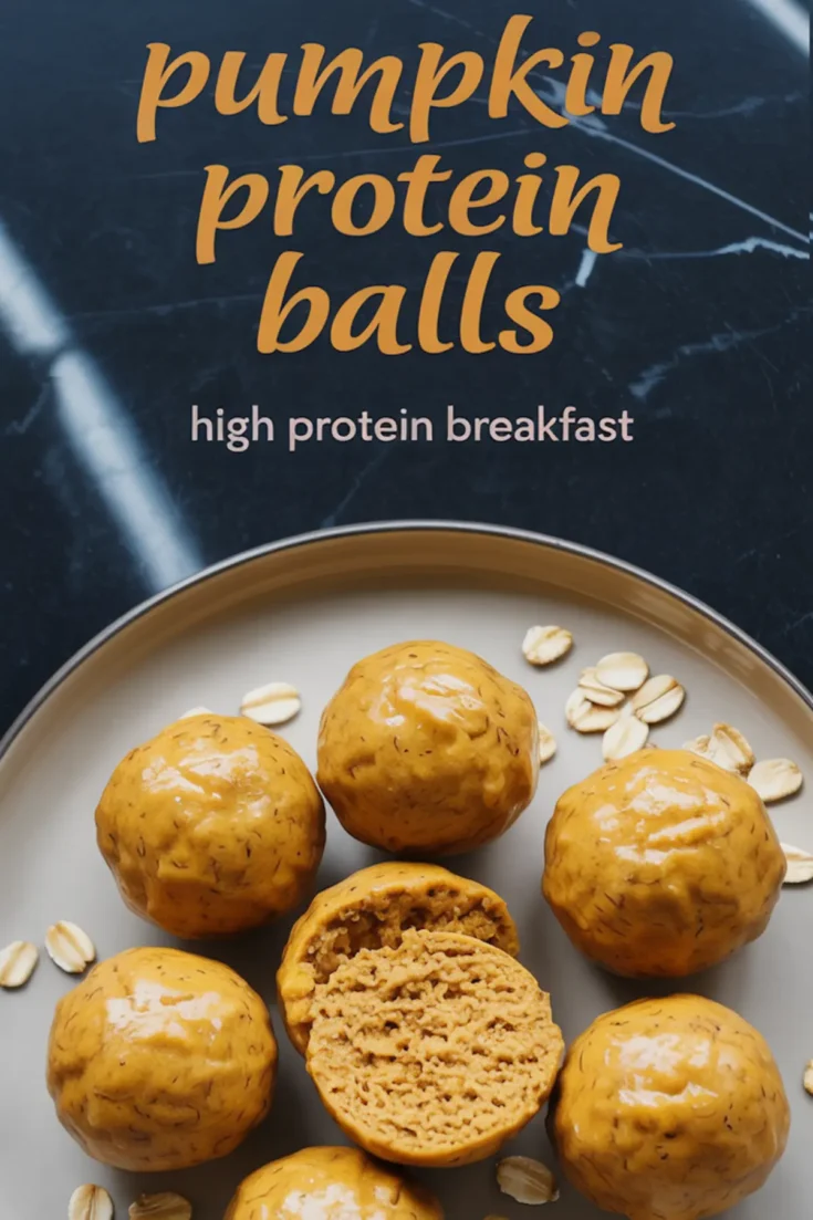 Plate of glossy pumpkin protein balls with one sliced open to reveal a moist, dense texture, surrounded by scattered oats on a black marble background, with text overlay promoting high protein breakfast.