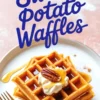 Stack of sweet potato waffles topped with whipped cream, maple syrup, and pecans on a white plate with gold utensils.