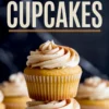 Stacked vanilla cupcakes topped with cinnamon-speckled buttercream frosting, with bold “Snickerdoodle Cupcakes” text overlaid on a dark background.