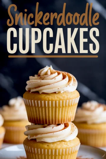 Stacked vanilla cupcakes topped with cinnamon-speckled buttercream frosting, with bold “Snickerdoodle Cupcakes” text overlaid on a dark background.