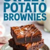Three thick sweet potato brownies stacked on a plate, drizzled with melted chocolate and garnished with flaky sea salt. The dark, fudgy layers and slightly cracked top showcase the rich, gooey texture.
