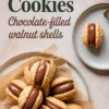 Top-down view of walnut-shaped cookies filled with glossy chocolate cream, arranged in a circular pattern on parchment paper, with an extra cookie on a plate beside a glass of milk.