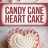 Alt: Close-up of a candy cane heart cake placed on a white plate, featuring white swirled frosting and a border of striped mini candy canes, with gold flakes on top for a festive touch.
