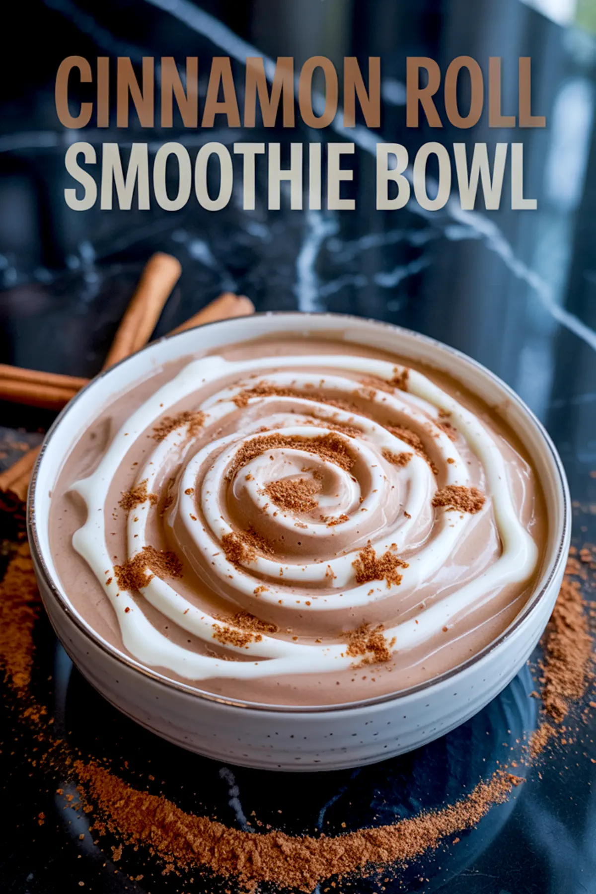 Cinnamon roll smoothie bowl styled with spiraled yogurt drizzle and sprinkled cinnamon powder, placed on a dark marble surface with cinnamon sticks.