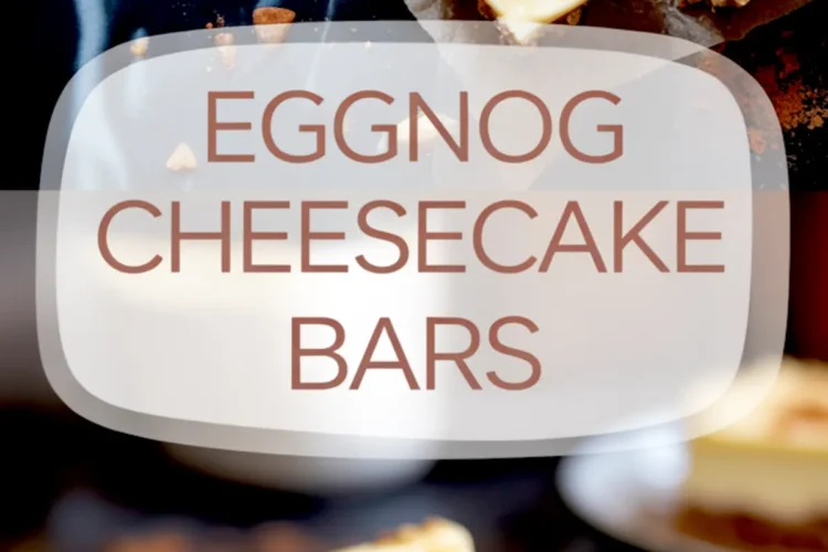 Close-up of a thick eggnog cheesecake bar on a dessert plate, showing a creamy eggnog filling with a cinnamon-dusted top and spiced cookie crust on a dark table.