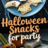 Assorted Halloween party snacks on a blue plate including ghost bananas with candy eyes, clementine pumpkins with celery stalks, and cheddar bat shapes on crackers, displayed with festive lettering.