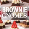 Whimsical gnome-themed brownies decorated with rich chocolate bases, piped vanilla frosting, halved strawberry hats, and golden candy noses, presented for Christmas dessert ideas or edible holiday crafts.